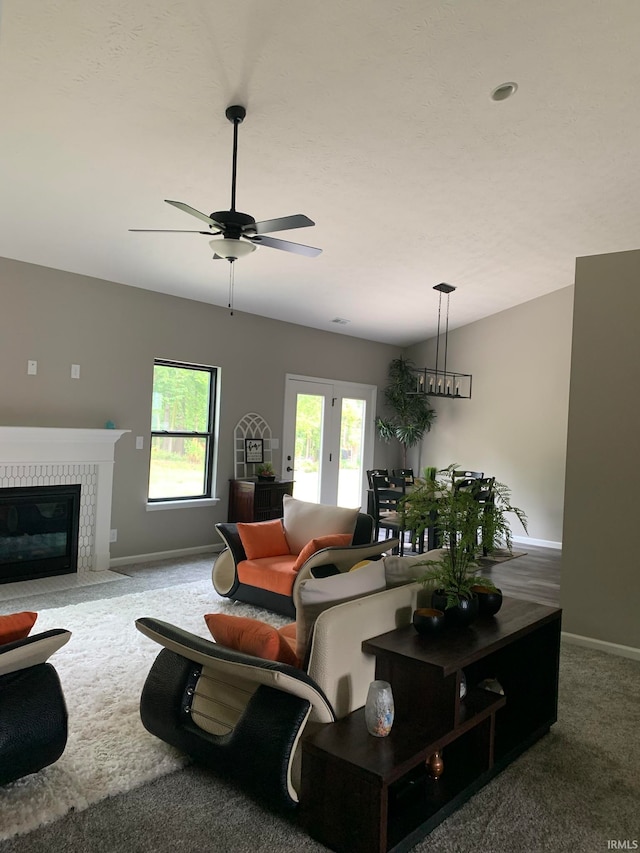 carpeted living room featuring a fireplace and ceiling fan