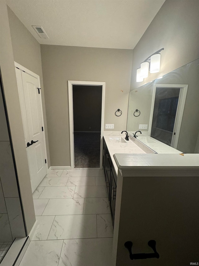 bathroom featuring a textured ceiling and vanity