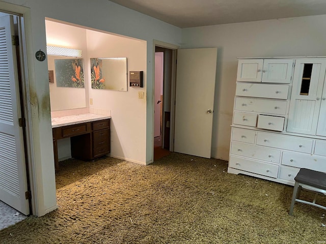 unfurnished bedroom featuring built in desk and dark colored carpet