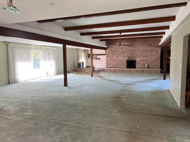 basement featuring brick wall, a fireplace, carpet flooring, and ceiling fan