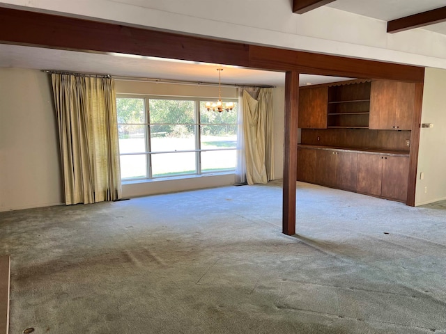 carpeted empty room featuring an inviting chandelier and beamed ceiling