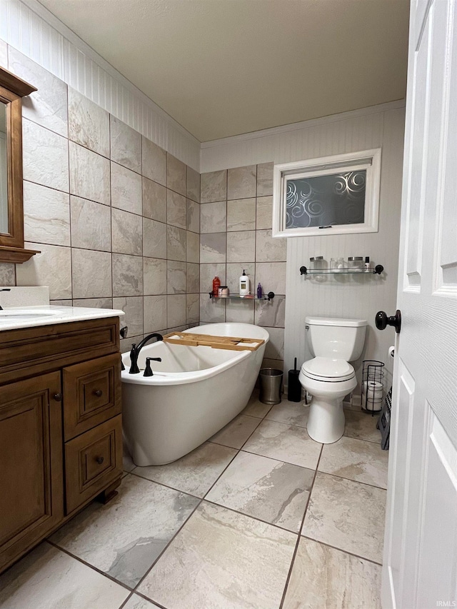 bathroom featuring vanity, tile walls, toilet, and a washtub