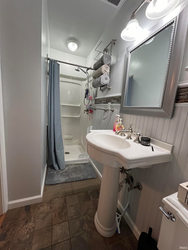 bathroom featuring toilet and a shower with shower curtain