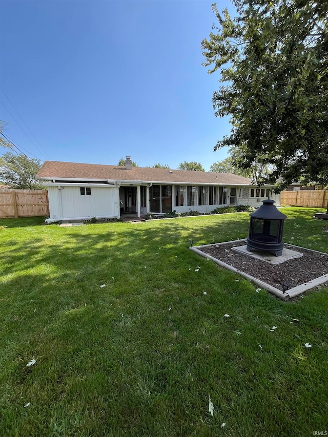 rear view of house featuring a yard