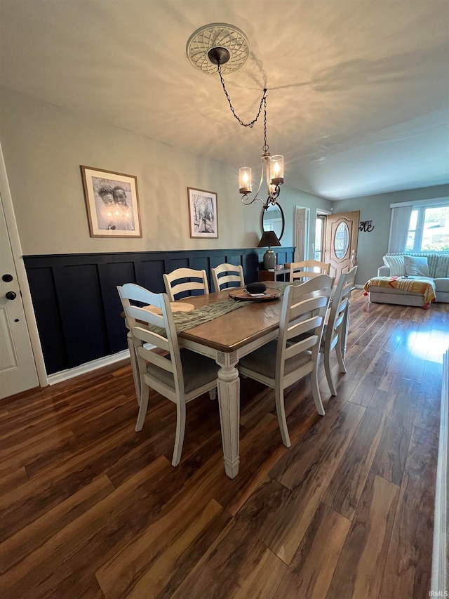 dining room with dark wood-type flooring and a chandelier