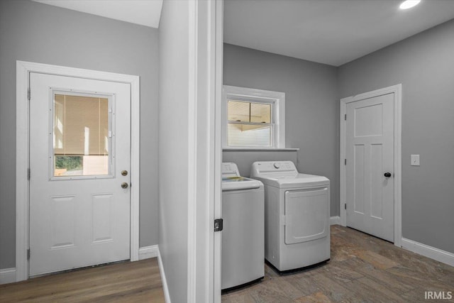 washroom with washer and clothes dryer, hardwood / wood-style flooring, and a healthy amount of sunlight