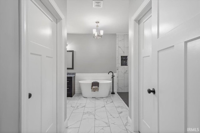 bathroom featuring plus walk in shower, a notable chandelier, and vanity