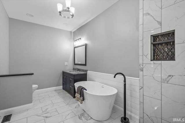 bathroom with tile walls, a tub, vanity, and toilet