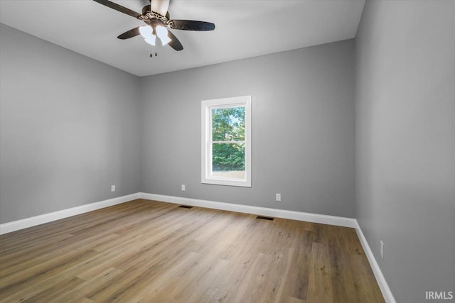 empty room with ceiling fan and light hardwood / wood-style flooring