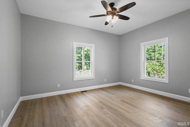 spare room featuring plenty of natural light, light hardwood / wood-style flooring, and ceiling fan