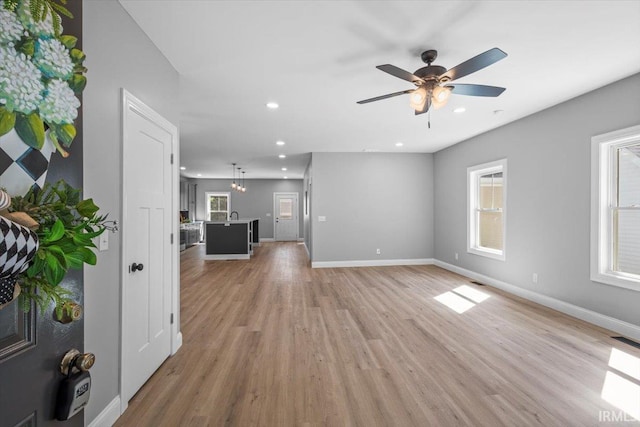 unfurnished living room with ceiling fan and light hardwood / wood-style floors