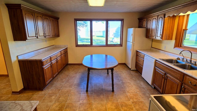 kitchen with light tile patterned floors, sink, and white appliances