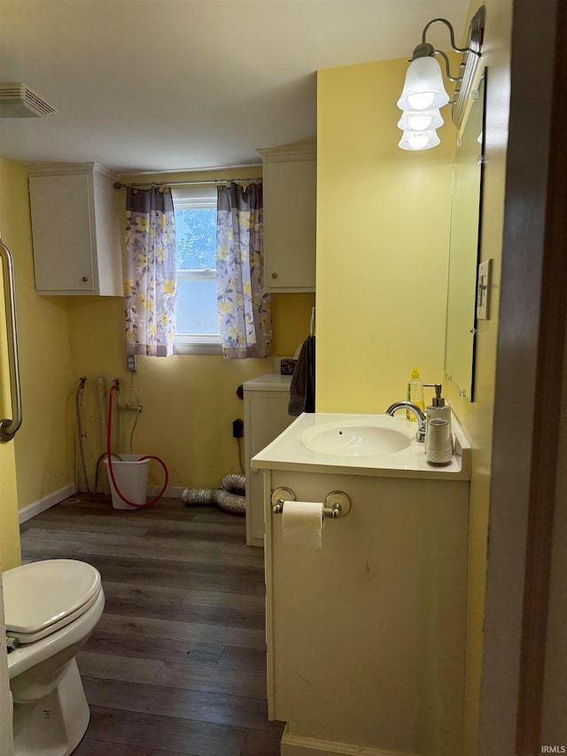 bathroom featuring vanity, toilet, and hardwood / wood-style flooring