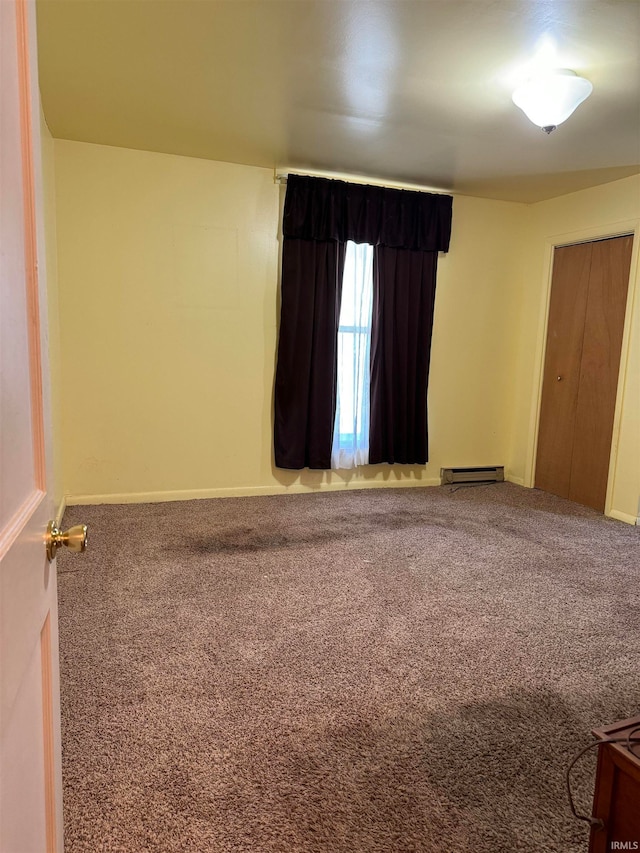 carpeted spare room with baseboard heating