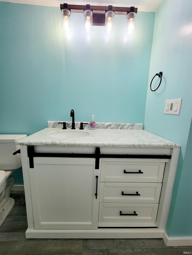 bathroom with hardwood / wood-style flooring, vanity, and toilet