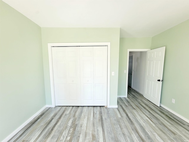 unfurnished bedroom featuring a closet and light hardwood / wood-style floors