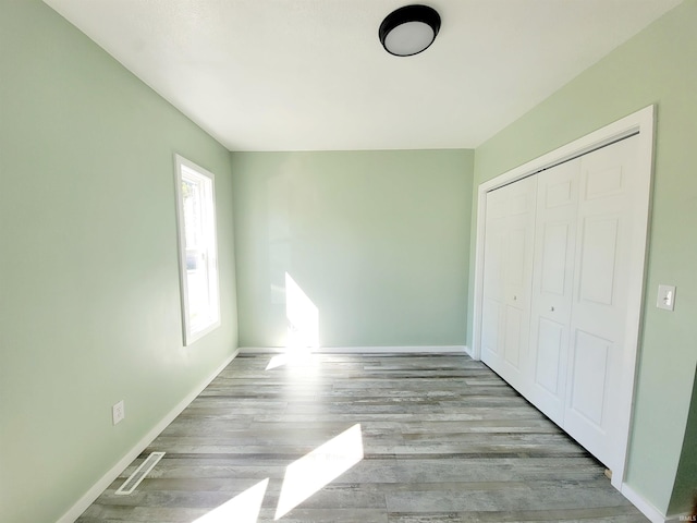 unfurnished bedroom featuring light wood-type flooring and a closet