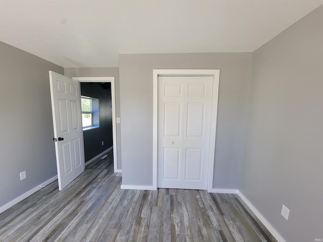 unfurnished bedroom featuring a closet and wood-type flooring