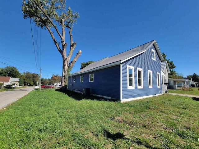 view of side of home featuring central AC and a lawn