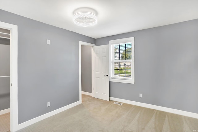 unfurnished bedroom featuring light carpet