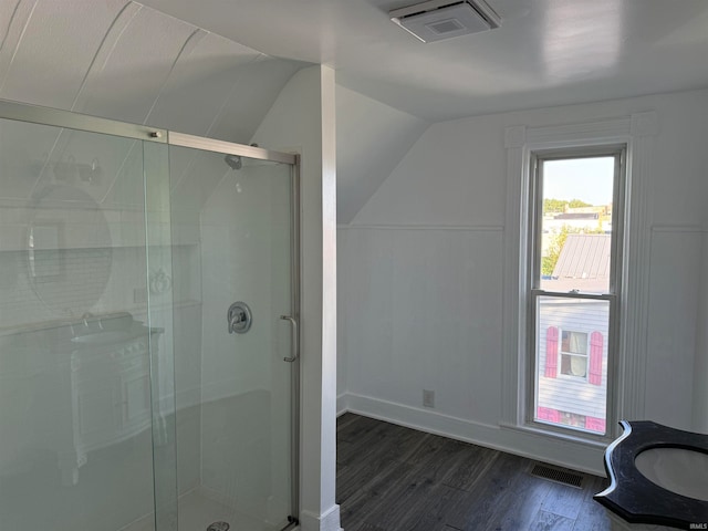 bathroom featuring wood-type flooring, lofted ceiling, vanity, and a shower with shower door