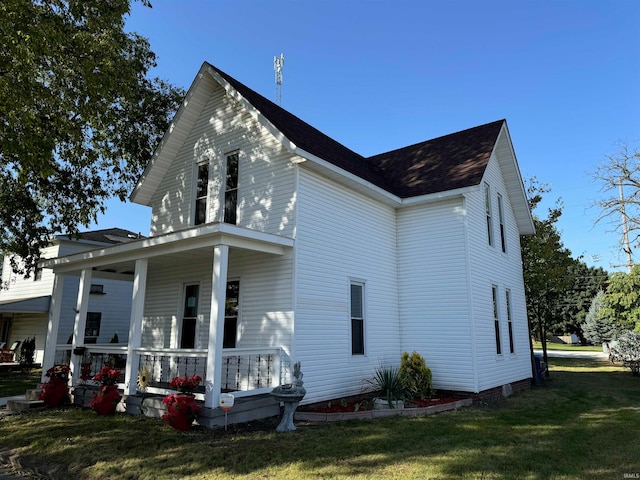 back of property featuring a lawn and covered porch