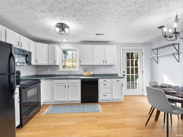 kitchen with sink, white cabinetry, and black appliances