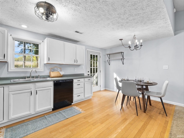 kitchen with white cabinets, sink, light hardwood / wood-style floors, black dishwasher, and a textured ceiling