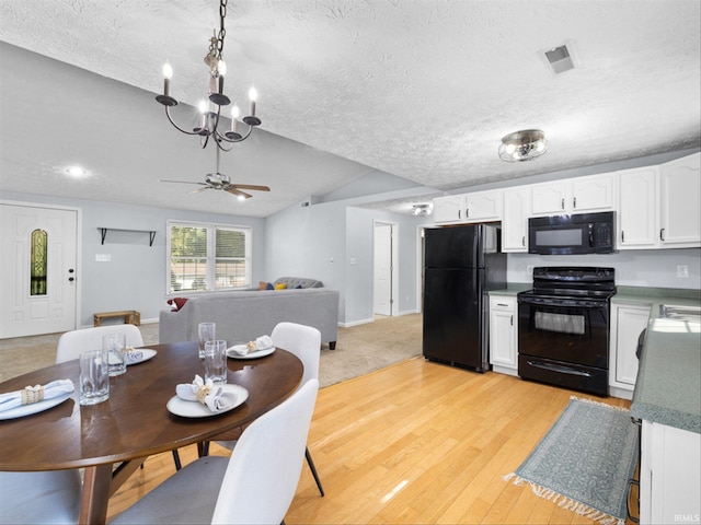 dining area featuring ceiling fan with notable chandelier, light hardwood / wood-style floors, and a textured ceiling