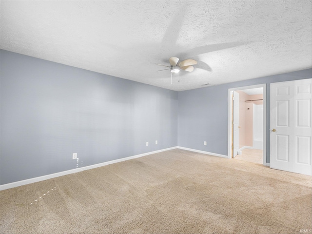 spare room featuring ceiling fan, a textured ceiling, and light carpet