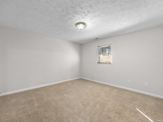 carpeted empty room with a textured ceiling