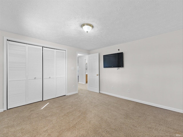 unfurnished bedroom featuring a closet, carpet flooring, and a textured ceiling