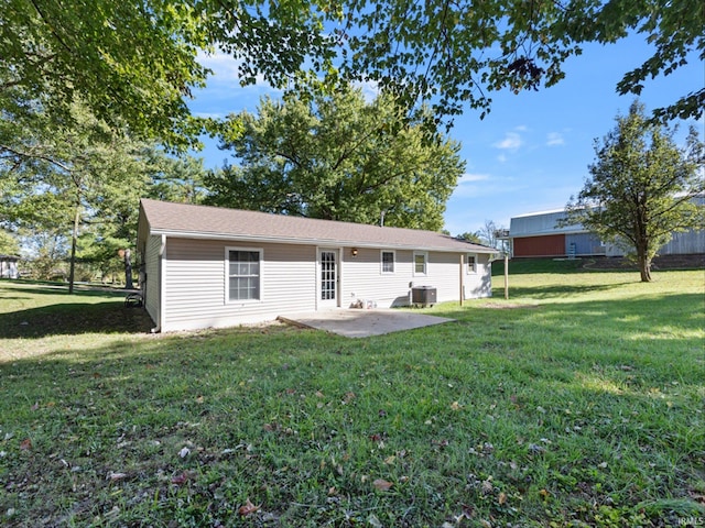 rear view of property with central AC unit, a patio, and a lawn