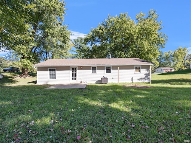 rear view of house with a yard, cooling unit, and a patio area