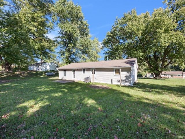 back of property with a yard and central AC unit