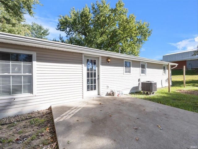 rear view of house with a lawn, a patio area, and central air condition unit