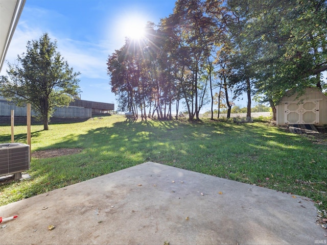 view of yard with central AC unit, a shed, and a patio area