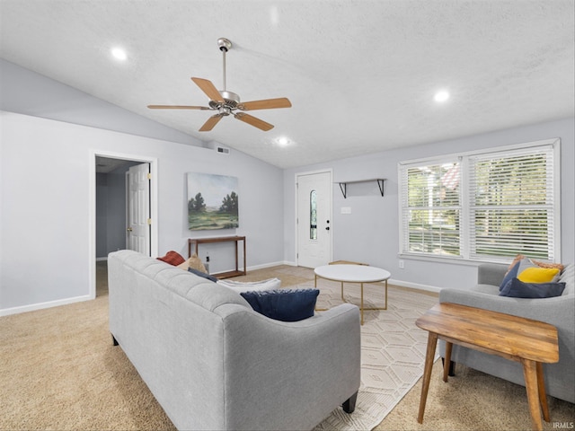 carpeted living room with ceiling fan, a textured ceiling, and vaulted ceiling