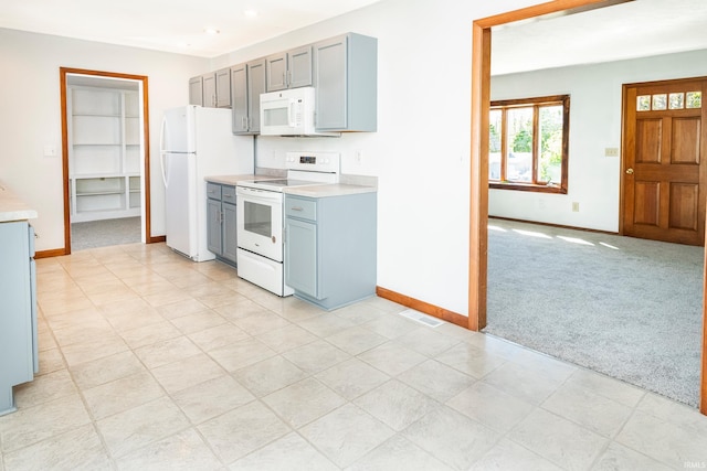 kitchen featuring light carpet and white appliances