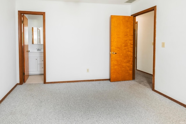 unfurnished bedroom with light carpet and ensuite bath