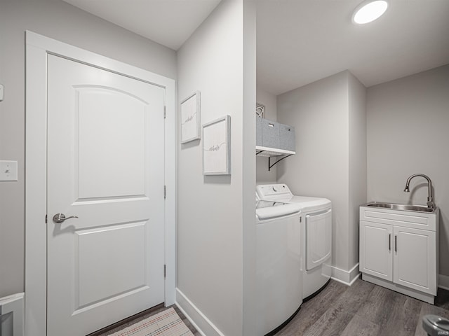 laundry area with cabinets, dark hardwood / wood-style floors, washer and dryer, and sink