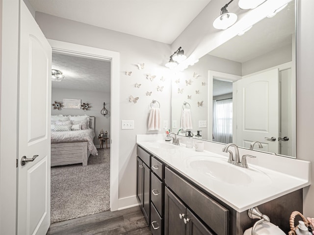 bathroom with wood-type flooring, vanity, and a textured ceiling