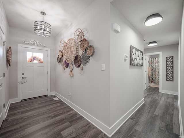 interior space featuring dark wood-type flooring and an inviting chandelier