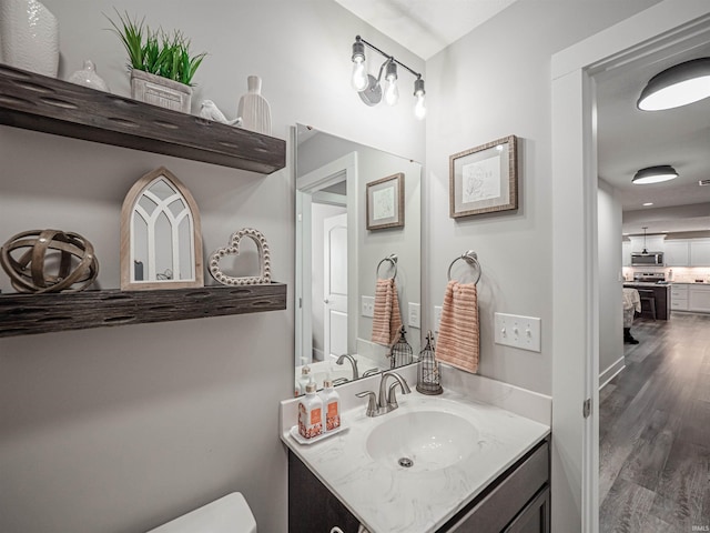 bathroom featuring hardwood / wood-style flooring, toilet, and vanity