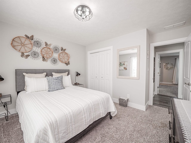 bedroom with light colored carpet, a textured ceiling, and a closet