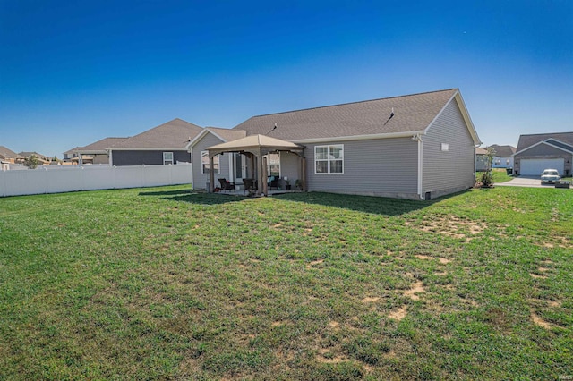 back of house with a patio and a lawn