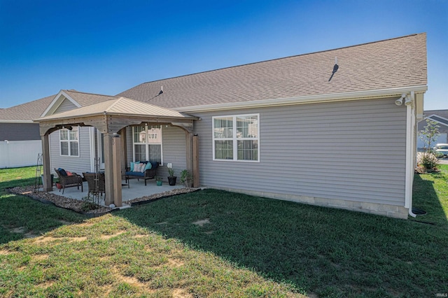 rear view of house featuring a yard and a patio area