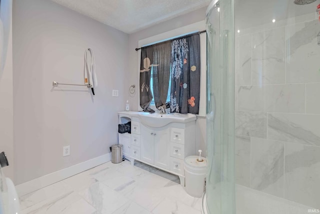 bathroom featuring toilet, a shower with door, vanity, and a textured ceiling