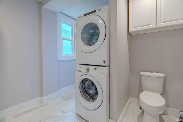 clothes washing area featuring stacked washer and clothes dryer