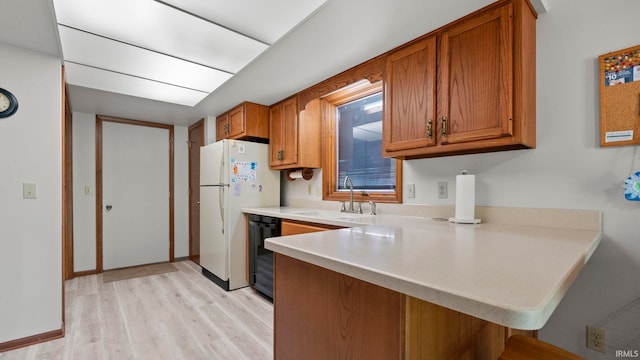 kitchen with a sink, light countertops, a breakfast bar, a peninsula, and brown cabinets